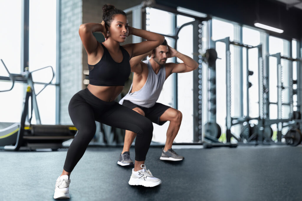 personal trainer and client doing squats in a gym for tax season fitness growth