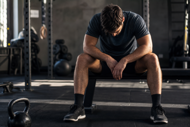 man experiencing a mid-summer performance block, seeking sports confidence coaching gym performance tips.